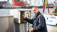 Der Elektroinstallateur-Meister Oliver Steinbrecher kontrolliert eine Stromzapfsäule im Hamburger Hafen.