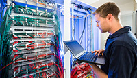 Der ausgebildete Fachinformatiker für Systemintegration Martin Behrend überprüft die vielen Kabelverbindungen.